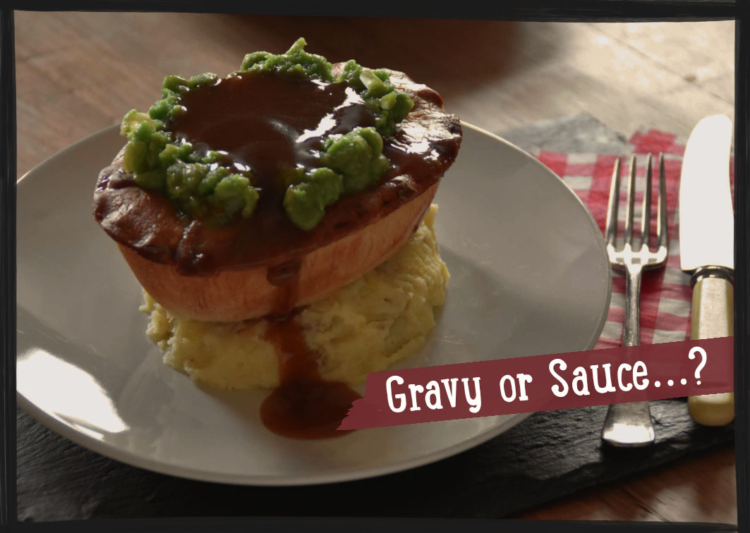 Hot pie served on a plate sitting on top of mashed potato and topped with mushy peas and gravy