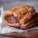 Puff pastry chunky sausage roll on a wooden board