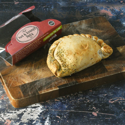 Chunk original pork & scrumpy pasty on a wooden cutting board.