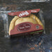A packaged Chunk original Steak Pasty , shown in its clear plastic clamshell packaging with a dark red cardboard label, set against a dark, rustic textured background. A great taste award winner.