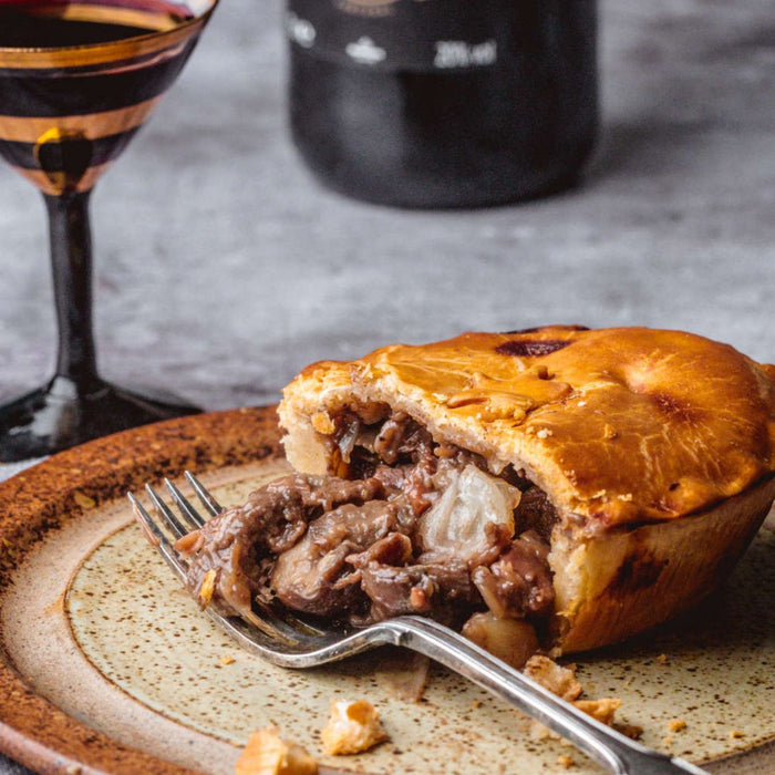 Chunk Venison & Port Pie served with on a rustic plate with a fork