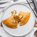 Handmade gluten-free veggie and vegan pasty baked in Devon, served on a white plate.