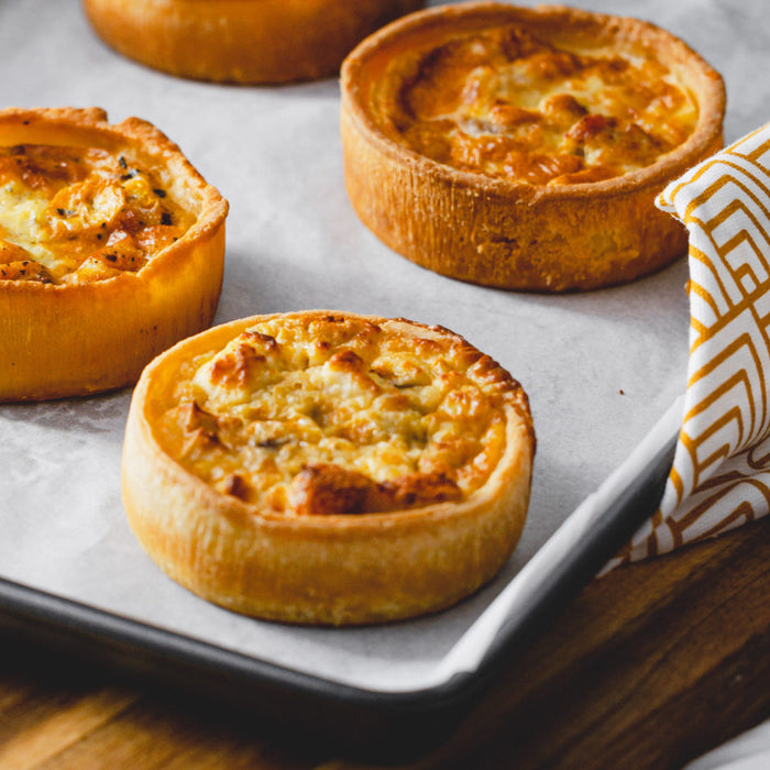 Handmade gluten-free quiche baked in Devon, featuring a golden pastry case and savoury filling.